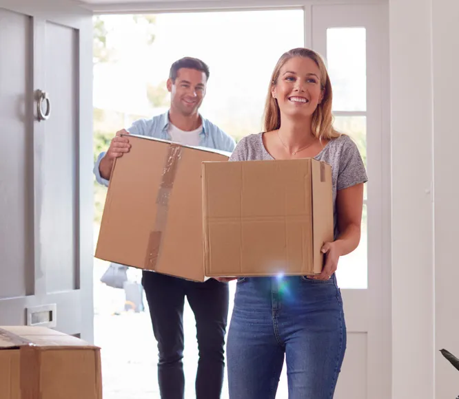 couple carrying moving boxes