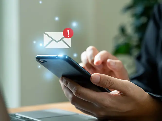 a person holding a mobile phone with an email icon floating above it