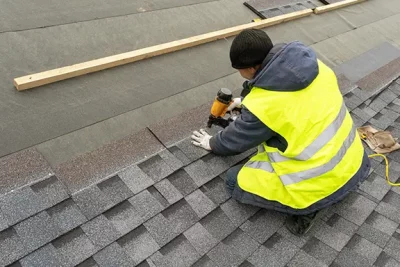 photo of roofer laying roof shingles