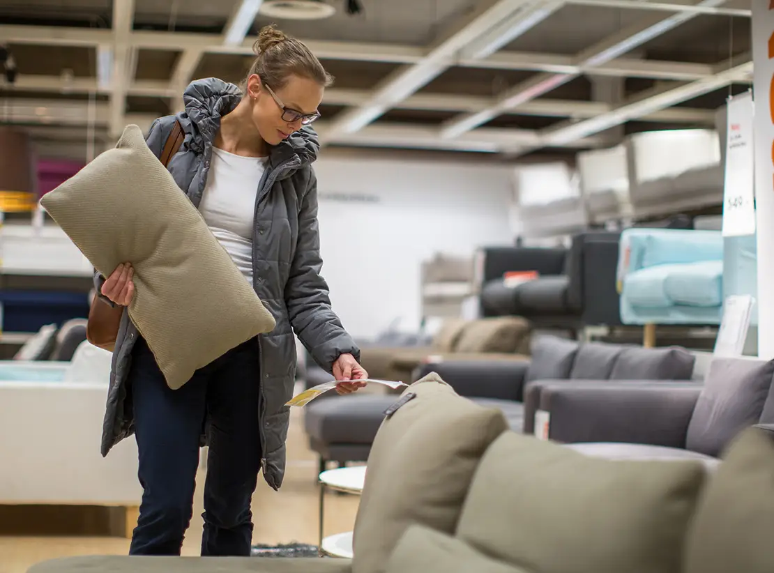 photo of a blonde woman browsing couches in a furniture store