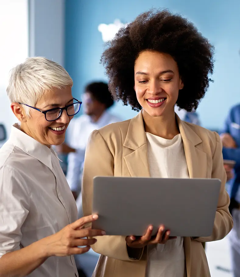 faq-businesswomen-smiling photo of two smiling businesswomen looking at a tablet